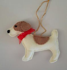 a brown and white dog ornament with a red ribbon