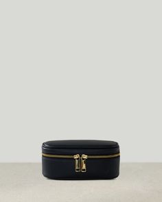 a black leather case with two gold zippers on the top and bottom, sitting on a table