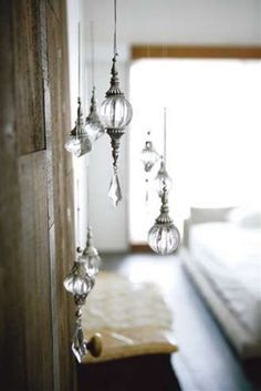 three glass ornaments hanging from the side of a wall next to a bed in a bedroom