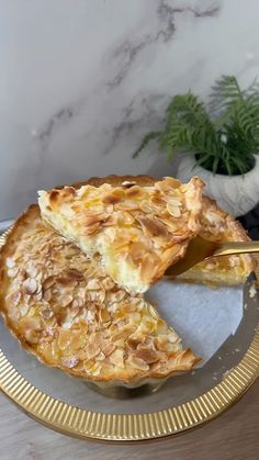 a piece of pie on a gold plate with a knife and fork next to it