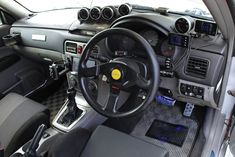 the interior of a car with steering wheel and dashboard