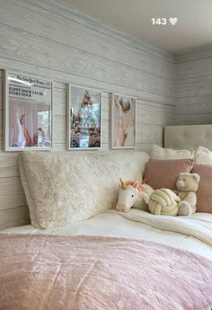 a bed with pillows and pictures on the wall