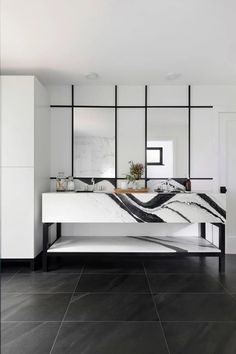 a modern bathroom with black and white marble countertops, two sinks and mirrors on the wall