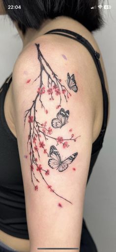 a woman's arm with butterflies and flowers tattooed on the back of her shoulder