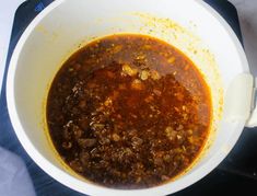 a white bowl filled with soup on top of a stove