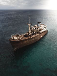 an old ship in the middle of the ocean