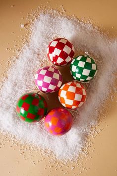 four decorated easter eggs sitting on top of some white salt and sprinkles