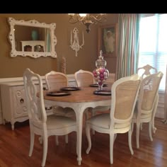 the dining room table is set with white chairs