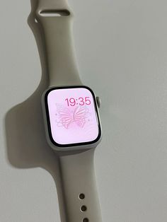 an apple watch with the time displayed on its face and wristband, in front of a white wall