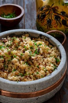 a bowl filled with rice and garnished with parsley next to other dishes