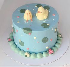 a blue cake with two little ducks on top