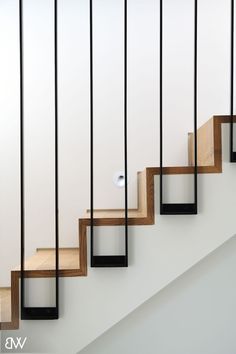 a set of stairs with wooden treads and metal handrails in a white room