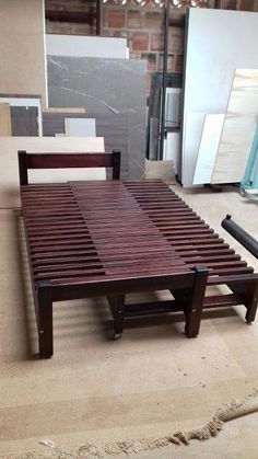 a wooden bed frame sitting on top of a floor next to a pile of boxes