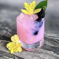 a pink cocktail with blackberries and yellow flowers