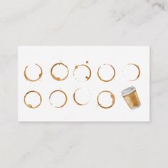 a cup of coffee sitting on top of a table next to some circles and rings