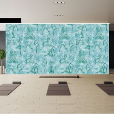 yoga mats are arranged on the floor in front of a wall with an artistic pattern