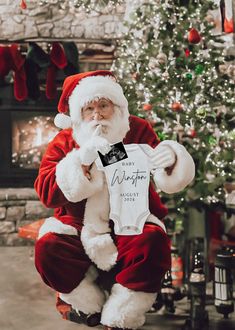 a man dressed as santa claus holding up a shirt