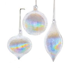 three glass ornaments hanging from strings on a white background, one with iridescent colors