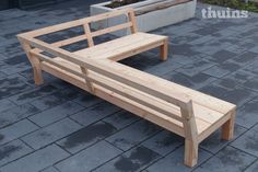 a wooden bench sitting on top of a sidewalk