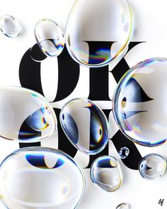 soap bubbles are floating in the air on a white surface with black and white letters