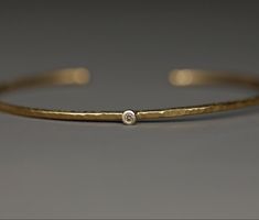 A handmade bangle made of 750 yellow gold with a brown diamond. Minimalist in design, it feels as light as a feather on the wrist. The hammered surface gives it a pretty structure, the fine matt finish creates a rich yellow gold tone. 750 white gold was chosen for the setting. The hoop is made to fit tightly. Its profile is rounded all around, which makes it very comfortable. A chic and elegant piece of jewelry that can also be beautifully combined with other bracelets. Dimensions: Width approx. Filigree Bangle, Hammered Bangles, The Bangles, Bangles Making, Handmade Bangles, Chic And Elegant, Brown Diamond, Recycled Gold, Real Gold