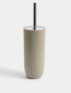 a toilet brush holder made out of woven material with a black metal tube in the middle