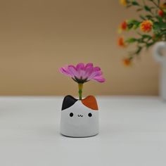 a vase with a flower in it sitting on a table