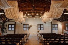 an empty church with white drapes hanging from the ceiling