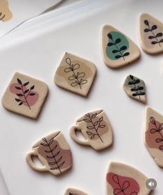 small ceramic coasters with designs on them sitting next to each other, including coffee cups and leaves