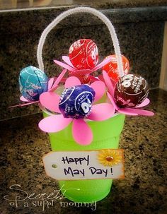 a green bucket filled with candy and flowers