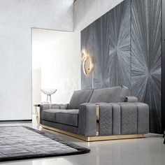 a modern living room with grey couches and gold accents on the wall, along with an area rug