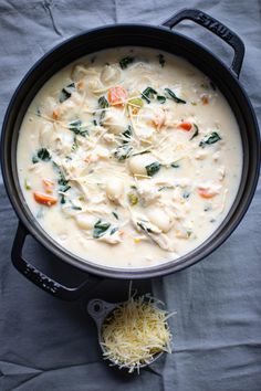 a pot filled with soup and cheese on top of a table