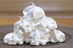 a pile of whipped cream sitting on top of a wooden table covered in white frosting