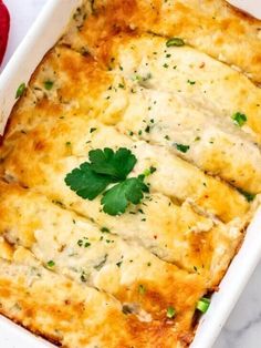 a casserole dish with meat, cheese and parsley in it on a marble surface