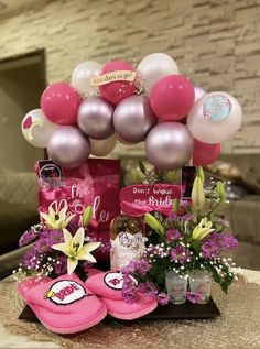 a table with pink slippers and balloons on it