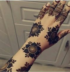 a woman's hand with henna tattoos on it