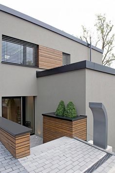 a modern house with wooden planters on the roof