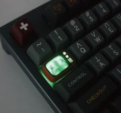 a computer keyboard with a green light on it's backlit keypads