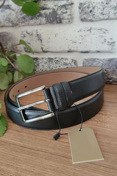 Enhance your wardrobe with our Black Smooth Dressing Belt for Men, a perfect blend of elegance and functionality. Crafted from genuine leather, this 3.5 cm (1 3/8") wide belt is designed to complement your trousers with sophistication. The sleek black color adds a timeless touch, making it a versatile accessory for any occasion. This belt features a polished silver buckle, providing a refined finish that enhances both casual and formal outfits. Whether you're dressing up for a special event or a Premium Silver Belt For Men, Classic Business Belt In Bridle Leather, Classic Bridle Leather Business Belt, Classic Bridle Leather Belt For Business, Classic Business Belt Buckles With Leather Strap, Formal Leather Belts And Suspenders, Black Leather Belts And Suspenders For Business, Leather Strap Belts And Suspenders For Business, Masculine Leather Belts And Suspenders For Business