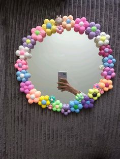 a person taking a selfie in front of a mirror with colorful balloons on it