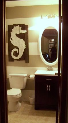 a bathroom with a toilet, sink and mirror in it's doorway way to another room