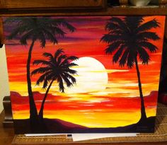 an easel painted with palm trees at sunset