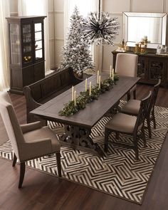 a dining room table with chairs and a christmas tree in the center surrounded by candles