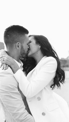 a man and woman kissing each other in black and white