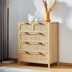 a wooden dresser with wicker drawers next to a window