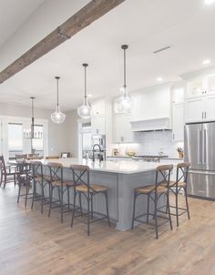 a large kitchen with an island and bar stools