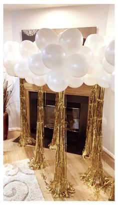 white and gold balloons in front of a fireplace