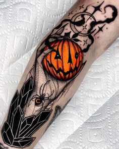 a man's leg with a halloween pumpkin tattoo on it