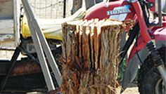 a red motorcycle parked next to a pile of wood