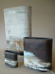 three vases sitting on top of a table next to each other